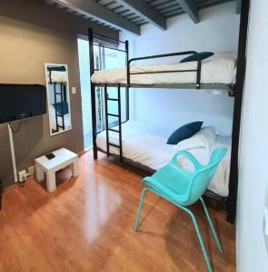 Habitación con 2 literas y una silla azul. en Habitación privada con terraza en Polanco., en Ciudad de México