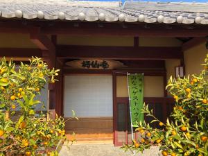 una entrada a un edificio con un naranjo en みなべゲストハウス en Minabe