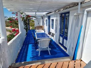 une terrasse avec une table et des chaises sur une maison dans l'établissement Mosselbank Beach Retreat 3, à Paternoster