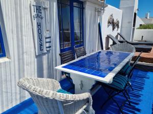 - une table et des chaises sur la terrasse couverte d'une maison dans l'établissement Mosselbank Beach Retreat 3, à Paternoster