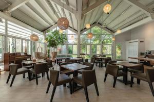 a restaurant with tables and chairs and windows at Cloud Sun Homestay in Zhixue