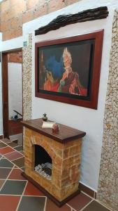 a painting of a woman on a wall with a fireplace at El Quijote Apartahotel in Jericó