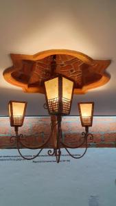 a chandelier with three lights hanging from a ceiling at El Quijote Apartahotel in Jericó