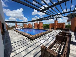 eine Terrasse mit Stühlen und einen Pool auf einem Gebäude in der Unterkunft La Foret 2 dormitorios in Santa Cruz de la Sierra