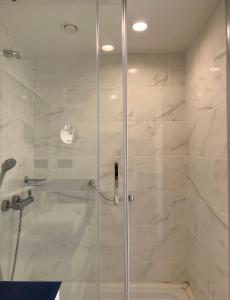 La salle de bains est pourvue d'une douche avec une porte en verre. dans l'établissement Orbi city With sea view, à Batoumi
