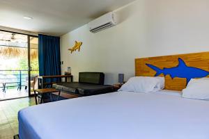 een slaapkamer met een groot bed met haaienstickers aan de muur bij Shark Town Mal Pais in Santa Teresa Beach