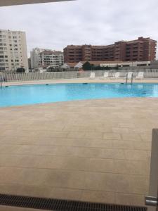 a large blue swimming pool with buildings in the background at DEPARTAMENTO EN LA SERENA A PASOS DE LA PLAYA in La Serena