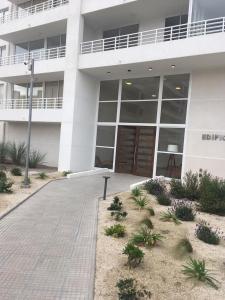 a large white building with a walkway in front of it at DEPARTAMENTO EN LA SERENA A PASOS DE LA PLAYA in La Serena