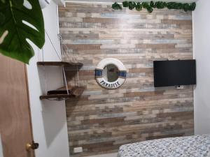 a wall made out of reclaimed wood with a tv at Casa Hostel San Andres in San Andrés