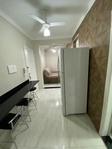 uma cozinha com um frigorífico e uma sala de estar em Apartamento frente mar Gonzaga Santos em Santos