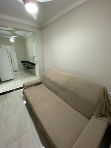 a couch in a living room with a piano at Apartamento frente mar Gonzaga Santos in Santos