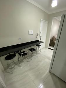 a room with a counter and stools in it at Apartamento frente mar Gonzaga Santos in Santos