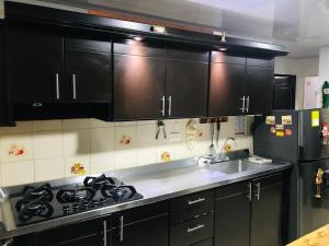 a kitchen with black cabinets and a stainless steel sink at EL DESCANSO DEL HACARITAMA in Melgar