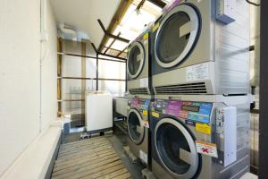a laundry room with three washing machines in it at Hotel Suntargas Ueno in Tokyo