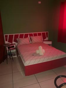 um quarto com uma cama cor-de-rosa com um rolo em Hotel Momentos em São Paulo