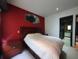1 dormitorio con cama blanca y pared roja en Hermoso y amplio departamento 3 rec Polanco, en Ciudad de México