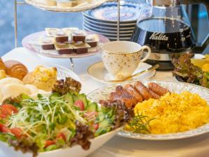 a table with plates of food and a cup of coffee at Hotel Suntargas Ueno in Tokyo