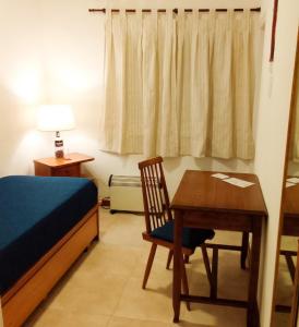 1 dormitorio con escritorio, 1 cama y 1 mesa en Hotel Medina B&B en Mar del Plata