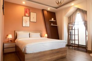 - une chambre avec un grand lit et une fenêtre dans l'établissement Dalat Blanc Hotel 2, à Khu Chi Lăng