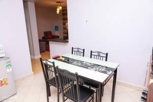 a kitchen with a table and chairs in a room at Luxe Furnished Apartments Unit 9 in Meru