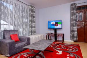 a living room with a chair and a tv at Luxe Furnished Apartments Unit 9 in Meru