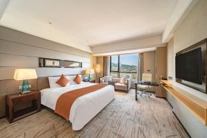 a hotel room with a large bed and a flat screen tv at Hotel Nikko Guangzhou - Complimentary shuttle service for concert event Baoneng&Olympic in Guangzhou