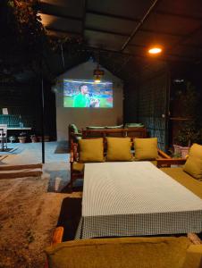 a living room with a couch and a tv at Cottages @ Village in Nainital