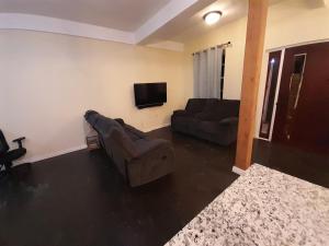sala de estar con 2 sofás y TV de pantalla plana en Tropical Suites en Choiseul