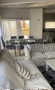 a living room with white couches and a table and chairs at BRISA de MAR in Valeria del Mar