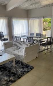sala de estar con sofá, mesas y sillas en BRISA de MAR en Valeria del Mar