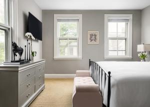 1 dormitorio con 1 cama, vestidor y ventanas en Flag House Inn en Annapolis