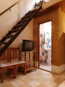 a living room with a staircase and a tv at DEPARTAMENtO LOFT in Posadas