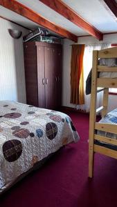 a bedroom with a bed and a dresser and a bunk bed at Acogedor departamento interior, a minutos del Lago in Llanquihue