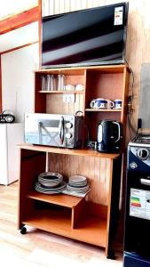 a shelf with plates and a microwave in a kitchen at Acogedor departamento interior, a minutos del Lago in Llanquihue