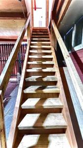 a stairway in a building with wooden steps at Acogedor departamento interior, a minutos del Lago in Llanquihue