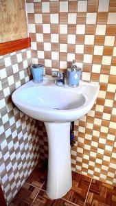 a bathroom with a white sink with two candles on it at Acogedor departamento interior, a minutos del Lago in Llanquihue