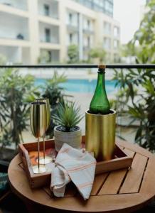 a wooden table with a bottle of wine and a glass at Enjoy Luxury Studio w/Pool @Embassy Gardens in Accra