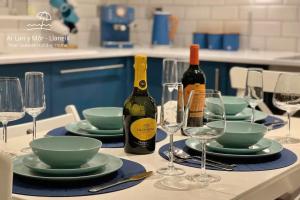 a table with glasses and bottles of wine on it at Ar Lan Y Mor - Stunning 2 bed coastal apartment in Llanelli