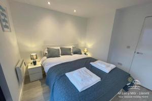 una camera da letto con un letto e due asciugamani di Ar Lan Y Mor - Stunning 2 bed coastal apartment a Llanelli