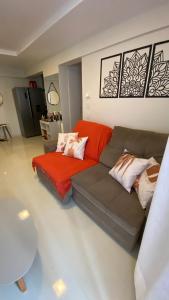 a living room with a couch and a red blanket at Apartamento altíssimo padrão - Piscina com vista in Mangaratiba