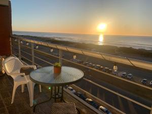 a table and chairs on a balcony with a view of the ocean at Casa Nostrum Priceless View Central Location 3BR 3BA in Punta del Este