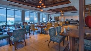 a restaurant with tables and chairs and windows at The Bayleaf Cavite in General Trias