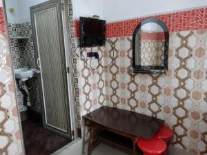 a bathroom with a bench and a mirror at Jagannath Guest House in Navadwīp