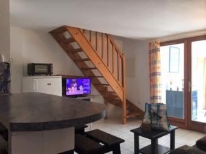 salon z telewizorem i schodami w obiekcie Pavillon lumineux 3 pièces avec piscine - 6 couchages, proche mer et commerces, parking privé - FR-1-229-818 w mieście Gruissan