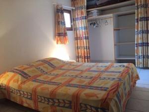 sypialnia z łóżkiem z kolorową narzutą w obiekcie Pavillon lumineux 3 pièces avec piscine - 6 couchages, proche mer et commerces, parking privé - FR-1-229-818 w mieście Gruissan