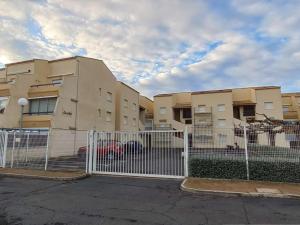 biały płot przed budynkiem w obiekcie Appartement avec piscine et parking, proche des commerces - FR-1-387-189 w mieście Marseillan +6 zdjęć