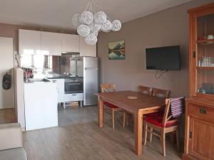 kuchnia i jadalnia ze stołem i lodówką w obiekcie Appart 2 pièces 6-8 pers, accès direct pistes - FR-1-322-514 w mieście Les Orres