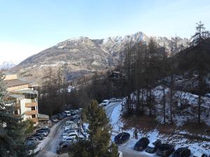 parking z samochodami zaparkowanymi przed górą w obiekcie Appart 2 pièces 6-8 pers, accès direct pistes - FR-1-322-514 w mieście Les Orres