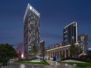 a tall building in a city at night at Grand New Century Hotel Wenzhou in Wenzhou