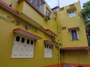 um edifício amarelo com portas e janelas brancas em Jagannath Guest House em Navadwīp